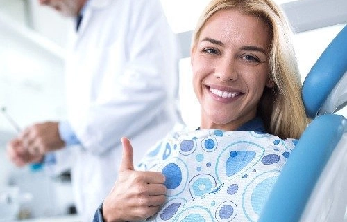 Glückliche Patientin nach Notfall-Behandlung beim Zahnarzt
