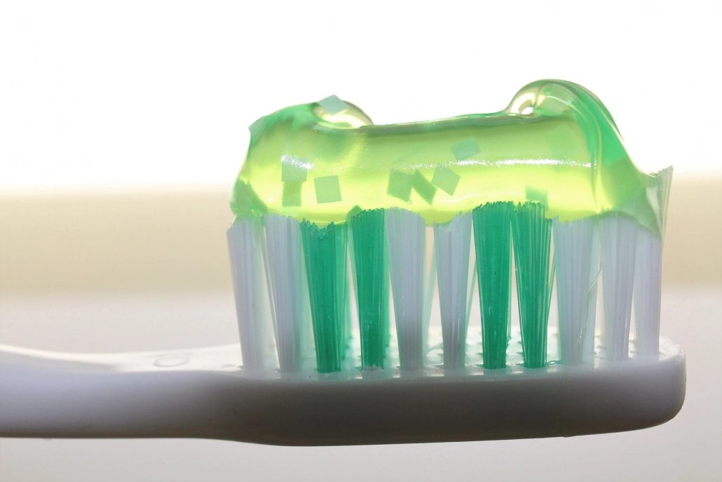 Zahnbürste mit transparent-grüner Zahnpasta für häusliche Prophylaxe